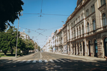 Obraz premium empty morning street in Zagreb, Croatia, stretches quietly, bathed in soft sunlight. Buildings line the thoroughfare, their façades whispering stories of the past, while the air carries a peaceful sti