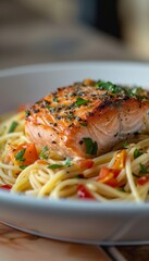 Gourmet pasta dish with seasoned salmon fillet and flavorful herbs in an elegant presentation