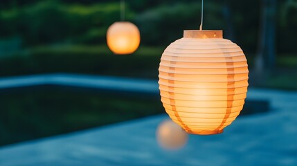 Obraz premium Illuminated Paper Lantern Hanging Over Pool at Dusk