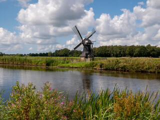 Naklejka premium Historic Watermill by the Tjonger River in Friesland, Netherlands