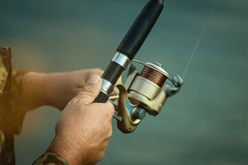 Obraz premium a man winds a reel on a fishing line