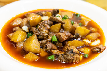 Simple and authentic Sichuan cuisine of braised pork with potato in gravy served in plate