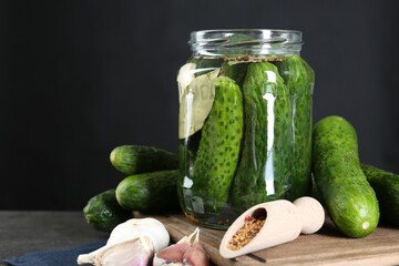 Making pickles. Fresh cucumbers and spices in jar on grey table