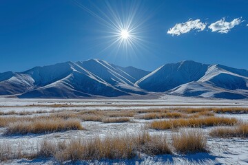 Snow-Capped Mountains and a Bright Sun over a Frozen Field