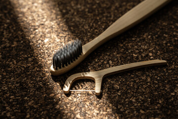 Bamboo Toothbrush and Floss Picks on Cork Surface