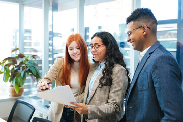 Collaborative project in bright co-working space led by young latin businesspeople. Teamwork and importance of community