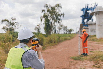 Surveyor engineer worker making measuring with theodolite tool equipment at construction site. Surveyors or explorer view construction sites or check security