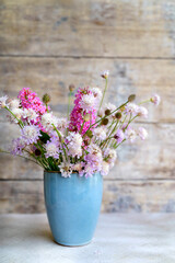 Small blue vase with beautiful summer flowers 
