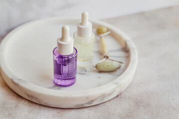 Bakuchiol serum and jade roller  in a marble plate 