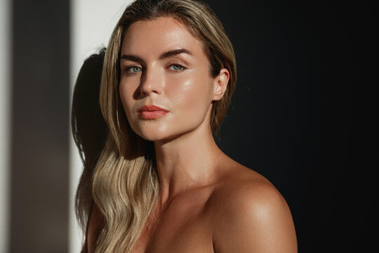 Portrait of  young woman with long blonde hair in sunlight