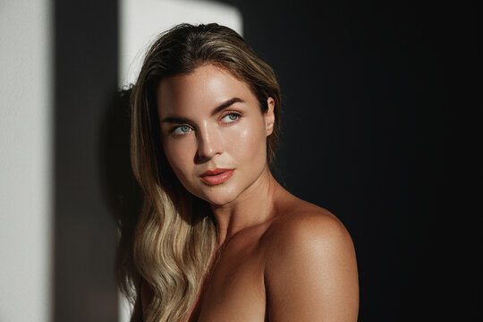 Portrait of  young woman with long blonde hair in sunlight