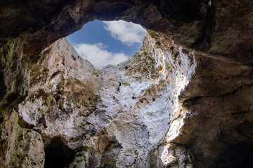 Obraz premium View of the sky from inside the grotto through an opening in the cliff, Polignano a Mare, Italy, Apulia