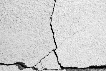 Big cracks on the old plastering wall. Long winding cracks in cement surface of an old building....