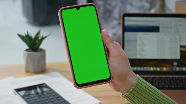 Cellphone user scrolling mockup display surfing internet at home office closeup