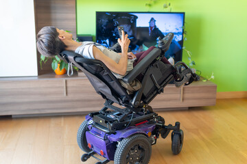 woman in the living room watching television lives with paralysis lying in an electrically propelled wheelchair, Standing wheelchairs.
