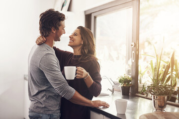 Coffee, man and woman in kitchen with embrace, romance and bonding together in morning. Love, morning and happy couple hug with drink, connection and relax with relationship commitment at home