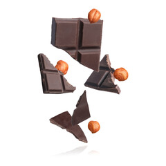 Pieces of tasty chocolate and hazelnuts falling on white background