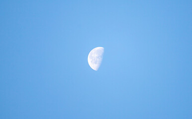 Crescent moon against blue sky.