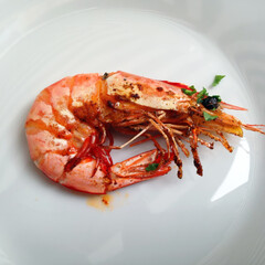 Luxury starter of grilled Atlantic prawn with garlic butter and chopped parsley