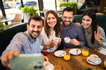 Group of friends at the restaurant taking selfie to capture the moment.