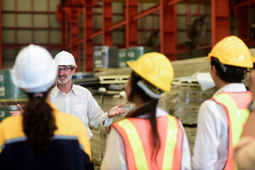 Professional Caucasian manager engineer wearing safety hardhat is training industry worker, workshop factory operator, mechanical engineering team production in heavy industrial manufacture factory.