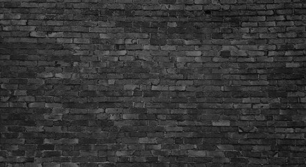 old dark black brick wall of an old architecture building. brick wall texture. dark grey masonry of stone blocks use as background with blank space for design.