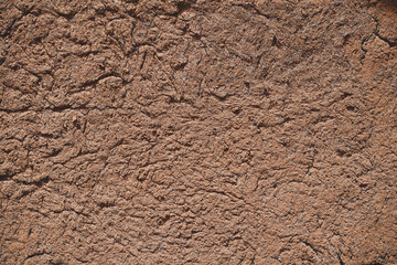 Wall of old mud house. Clay wall, surface texture. Close up.