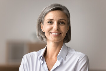 Close up head shot portrait of smiling aged businesswoman, feel happy after conducting seminar,...