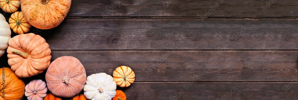 Aufkleber fall corner border of pumpkins of various sizes and colors over a rustic dark wood banner background
