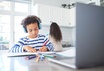 Naklejka premium Boy, headphones and e learning with laptop at house for education, writing assessment and studying. Child, stationery and online class for creative drawing, colourful sketch and childhood development
