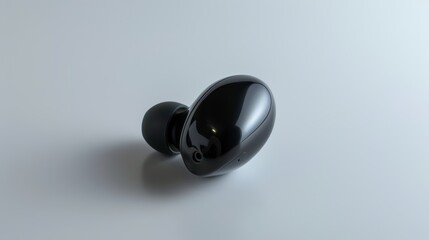 Stylish black wireless earbud resting on a simple background, perfect for showcasing modern audio technology.