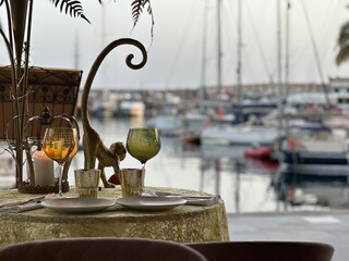 Wine glass in restaurant with faded harbor in background