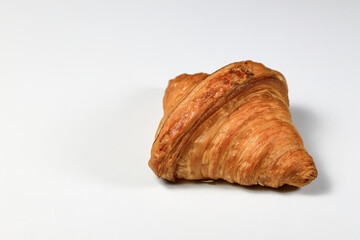 Freshly baked croissant,  Brown crispy croissants isolated on white background. French pastry closeup photo. Buttered bread croissant isolated on white background.