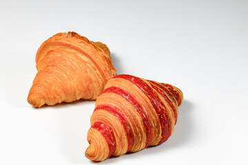 Freshly baked croissant, Brown crispy and Double Rasberry croissant isolated on white background. French pastry closeup photo. Buttered bread croissant.
