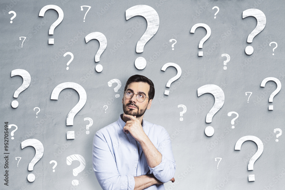 Poster thoughtful man surrounded by question marks on a gray background, symbolizing uncertainty and seekin