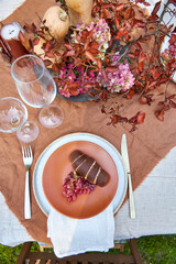 Fall table setting with pumpkins and leaves and hydrangea in brown and burgundy tones