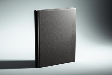 Black hardcover book mockup on a light grey background with shadow. 3D Rendering