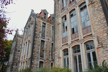 Fototapeta premium Old buildings in Parque Dom Carlos I, located in Caldas da Rainha, Portugal. These historic stone structures are set amidst lush greenery, creating a peaceful and picturesque scene.