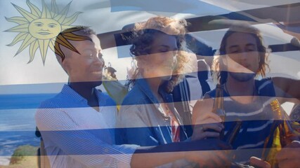 Friends enjoying drinks at beach with Uruguay flag animation in background - Powered by Adobe