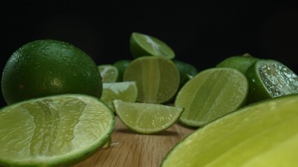 Close-up, a vibrant slice of fresh lime rests upon a rustic wooden cutting board, exuding freshness and vitality. The translucent membranes of the green lime slice placed on cutting board. Comestible.