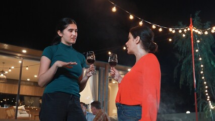 Family gather celebrate holiday. Mother and grandmother drink wine and talking at dinner party for...
