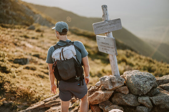 Hiker with backpack stops at a trail sign along Appalachian Trail