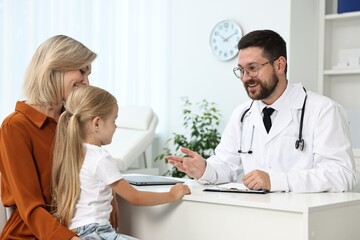 Doctor consulting little girl and her mother in hospital