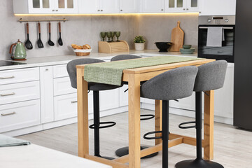 Bar stools near table in stylish kitchen
