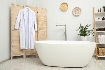 Stylish bathroom interior with folding screen and tub