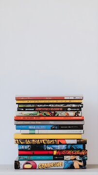 A stack of various comic books with their colorful spines visible, set against a minimalist light-colored background, perfect for text overlay