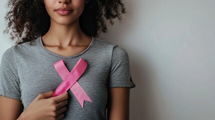 Pink Ribbon Held in Hand Against Wooden Background Cancer Day