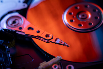 Open hard disk drive with visible read-write head and platters. Macro shot.