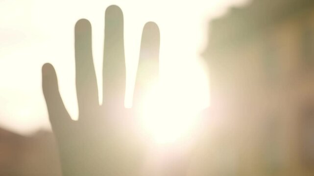 focus on hand of young black man reflected in sunset light