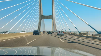 Peel and stick wall murals Vasco da Gama Bridge stretches over the Tagus River, carrying vehicles in bright daylight.